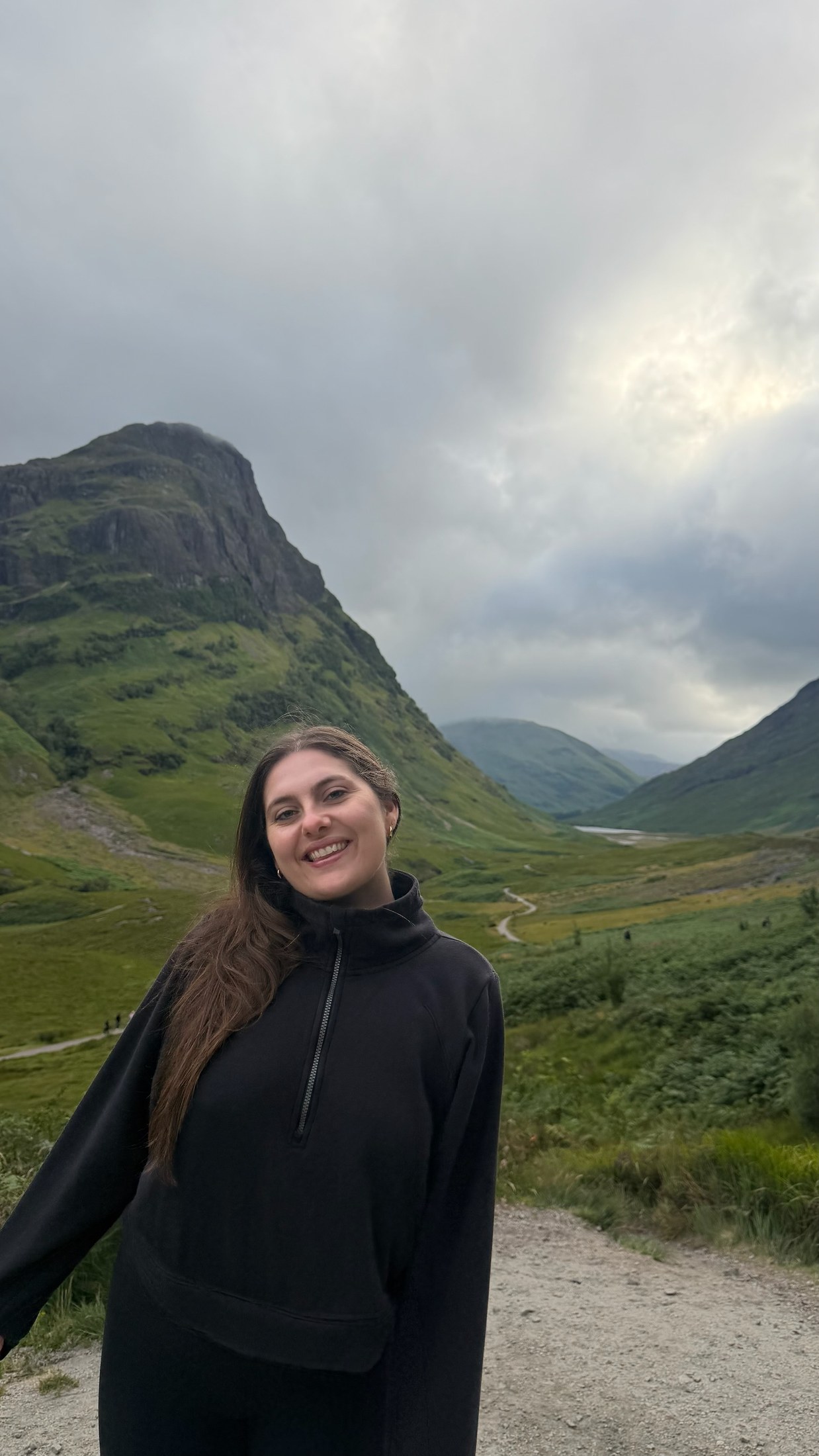 Portrait of Keragan smiling in a green mountain landscape.